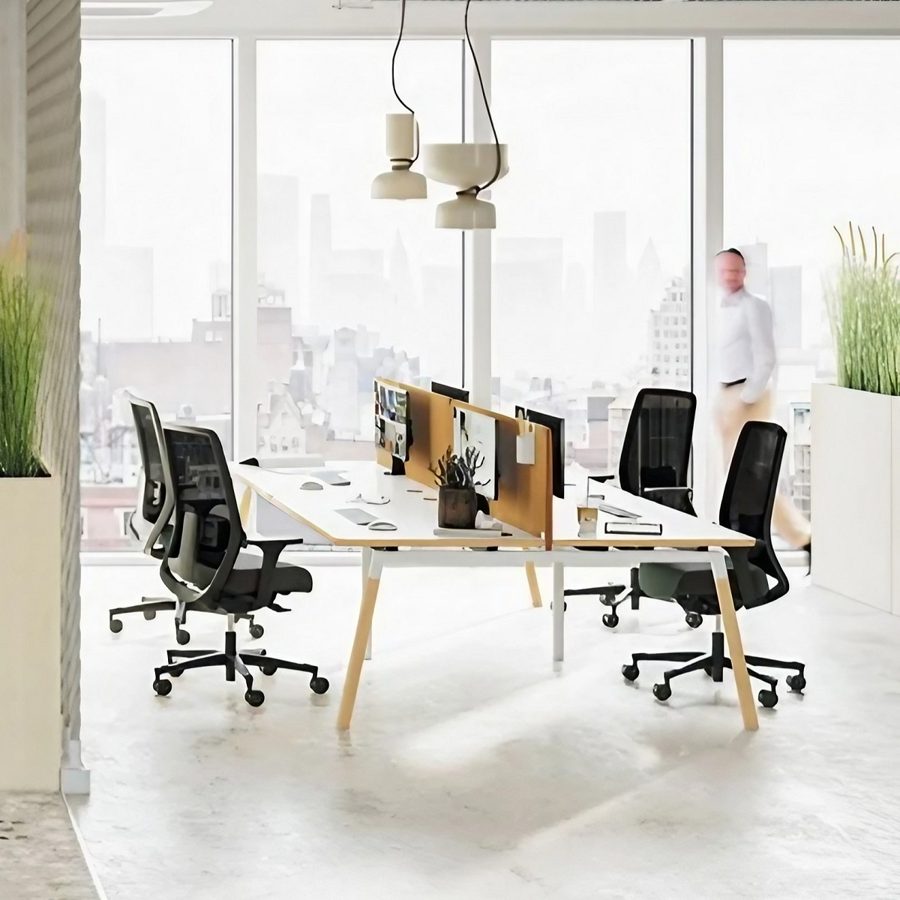 Bureau bench quatre personnes avec piètement en bois dans un open space lumineux